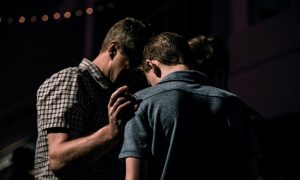 Two men at a Barcelona gay cruise club. One man puts his hand on the other's shoulder in a supportive gesture. Jack Sharp photo.