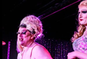 Drag queens perform at a gay bar in Manchester, UK. Nightlife scene with performers in wigs and makeup. Gay travel destination.