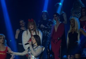 La Boum Milano: Drag queens perform on stage. Gay nightlife in Milan, Italy. LGBTQ+ travel advice. Performers in glamorous outfits.