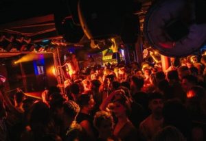 Sub 101 Manchester: A packed gay club scene with dancing men under vibrant lights. A lively night out in Manchester's gay village.