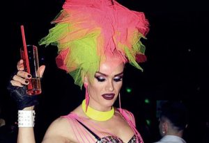 Drag queen at SuperFabric Club, Istanbul. Pink and green headpiece, holding a drink. Gay nightlife in Turkey. LGBTQ+ travel.