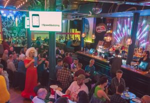 The Brewers Manchester: Gay bar scene with a drag queen performer hosting a SpeedQuizzing event. Men are seated at tables, enjoying drinks.