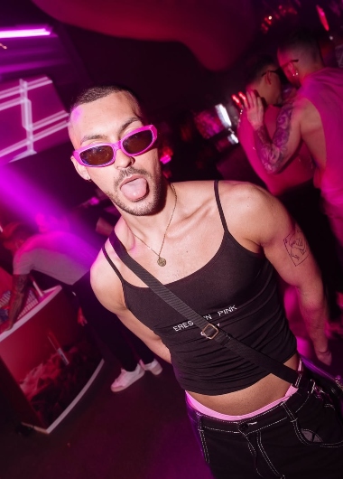 Party gay in a strap vest, and pink glasses having fun in Madrid gay club