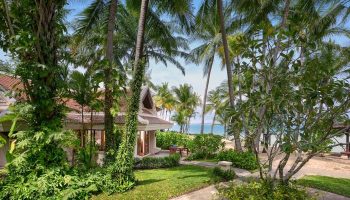 Santiburi Koh Samui deluxe beachfront villa exterior. Tropical gay travel destination with palm trees, beach, and luxurious villa.