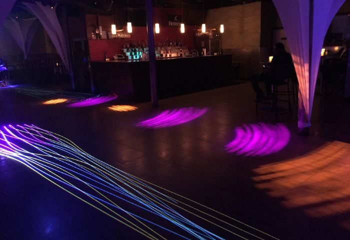 Club Boi interior. Bar with Hennessy logo, dance floor with purple and orange lights, and a man seated. 1-18.jpg. Gay travel advice.