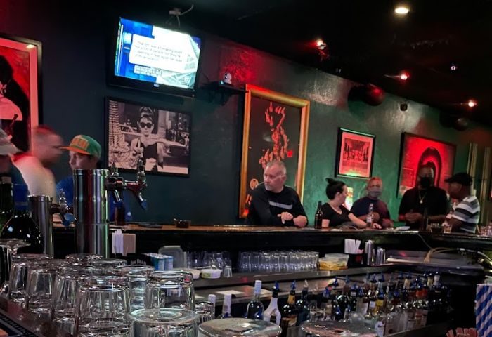 The Corner Pub: Interior view of a gay bar with patrons at the counter, drinks, and TV. A popular gay travel destination. 1-2.jpg