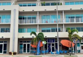 Infinity Lounge, gay travel advice: Exterior view of the lounge with outdoor seating, palm trees, and modern architecture. Gay bar.