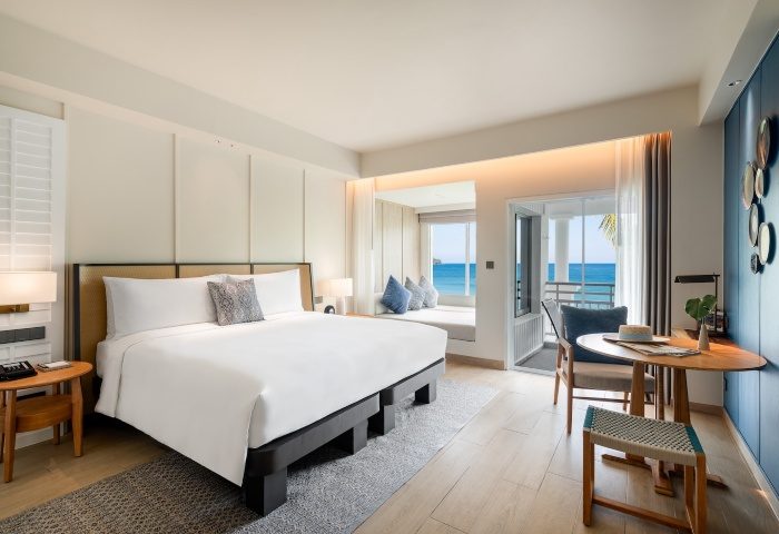 SAii Laguna Phuket ocean-front balcony king room. Modern gay-friendly hotel bedroom with king-size bed, ocean view, and stylish decor. Luxury travel.