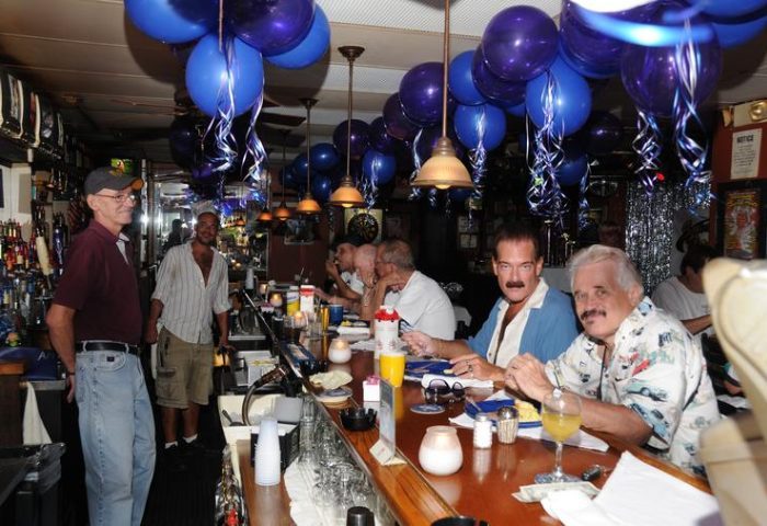 Interior of Smarty Pants Bar, a gay bar, with men at the bar, blue balloons, and bartenders. 1.jpg, a gay travel destination.