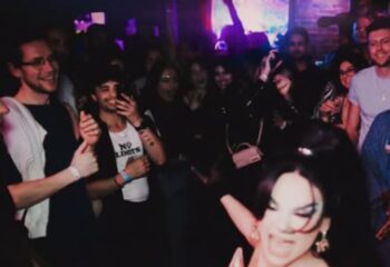 Inside 101 Club Roma, a crowded gay club. People are dancing, smiling, and enjoying the vibrant atmosphere. Gay travel advice.