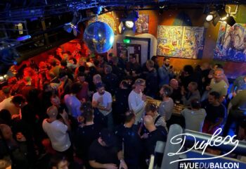 Duplex gay bar view. Men gather under a disco ball. Nightlife scene for gay men travel. Paris's Duplex club.