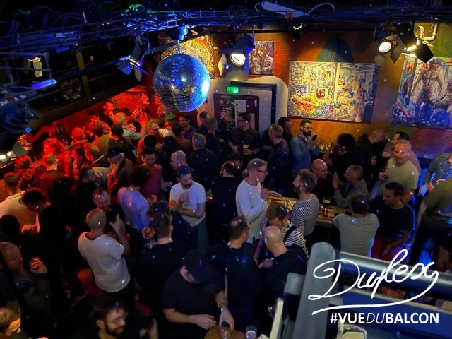 Duplex gay bar view. Men gather under a disco ball. Nightlife scene for gay men travel. Paris's Duplex club.