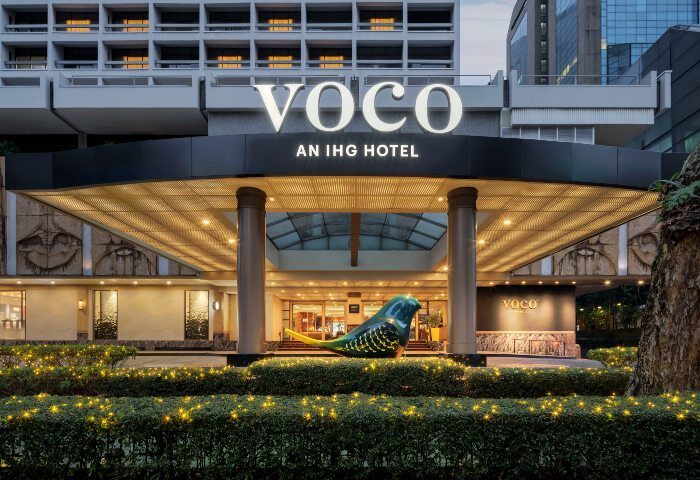 Entrance of voco Orchard Singapore, an IHG Hotel. Bird sculpture, bright lights, and modern architecture. A gay-friendly hotel in Singapore.