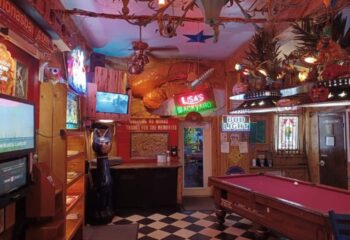 Interior of Mona's Cocktail Lounge, a gay bar. Pool table, TVs, neon signs, and quirky decor. A fun, welcoming space for gay men's travel. 2-10.jpg