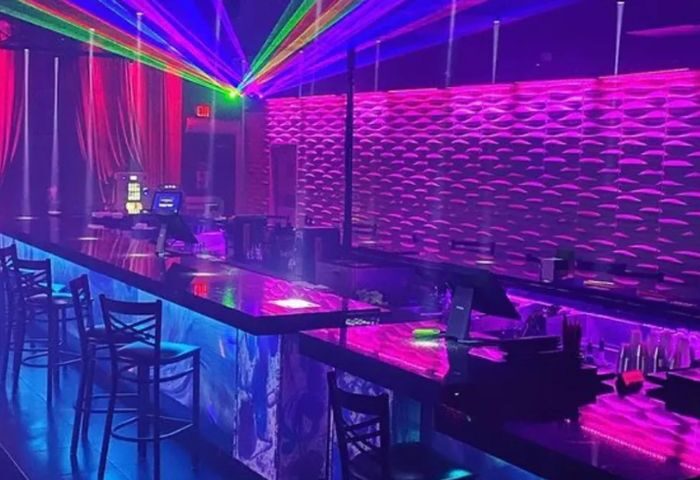 Interior of Boardwalk Bar, a gay bar, featuring vibrant laser lights, a sleek bar counter, and modern decor. Nightlife hotspot. 2-11.jpg