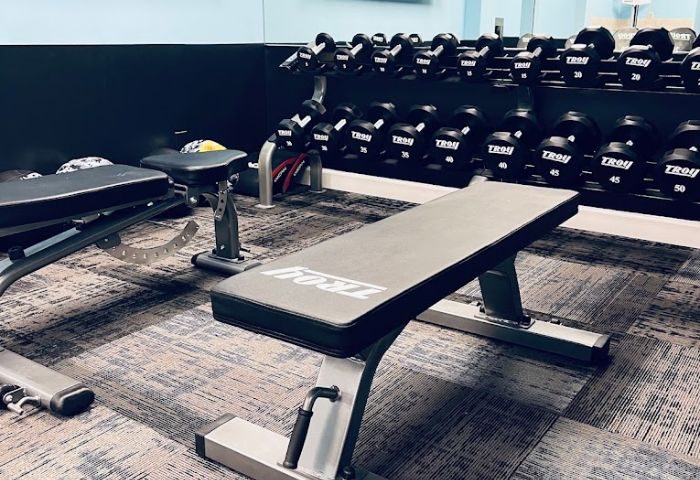 Wilton Social Club gym: Weight training area with benches and dumbbells. Perfect for gay men's fitness travel. #gaytravel #gym #fitness