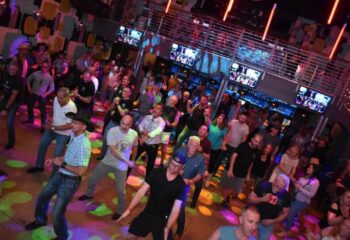 Hunters Wilton Manors: A packed gay bar dance floor with men dancing under colorful lights. Nightlife scene, gay travel advice.