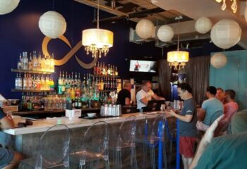 Infinity Lounge interior. Gay bar scene with men at the bar, bottles, and stylish decor. Gay travel destination. 2-7.jpg