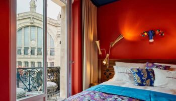 25hours Hotel Terminus Nord, Paris. Colorful room with balcony view. Gay-friendly hotel. Quirky design, vibrant colors, and cozy bed.