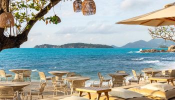 SAii Koh Samui Villas beachside dining. Tables and chairs on the sand, with ocean views. Perfect for gay travel and romantic getaways.