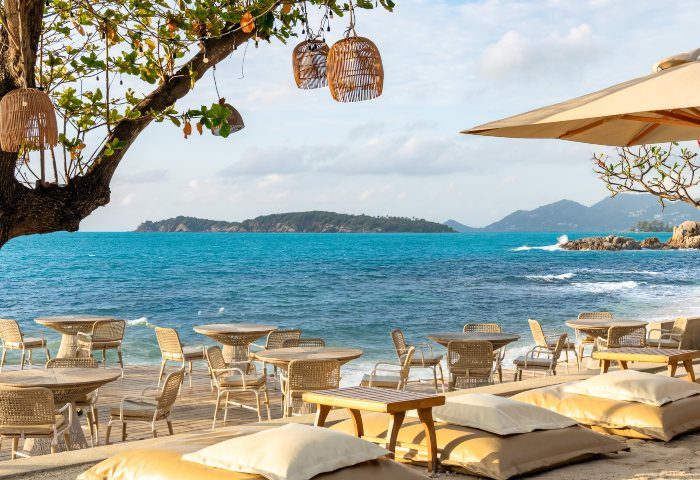 SAii Koh Samui Villas beachside dining. Tables and chairs on the sand, with ocean views. Perfect for gay travel and romantic getaways.