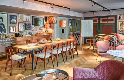 25hours Hotel Terminus Nord meeting room. Long table with chairs, colorful decor, art, and a whiteboard. LGBT friendly hotel in Paris.