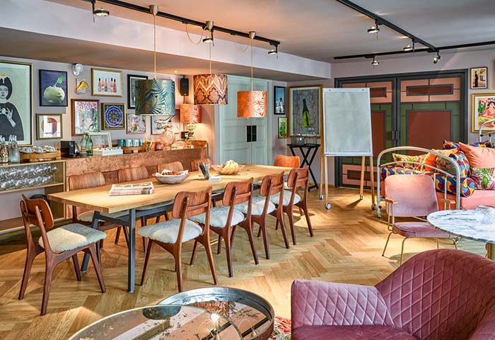 25hours Hotel Terminus Nord meeting room. Long table with chairs, colorful decor, art, and a whiteboard. LGBT friendly hotel in Paris.