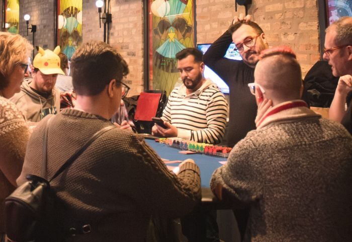 Patrons at 2Bears Tavern, an Uptown Chicago gay bar, play poker. The bar features unique artwork and a welcoming atmosphere. #GayTravel