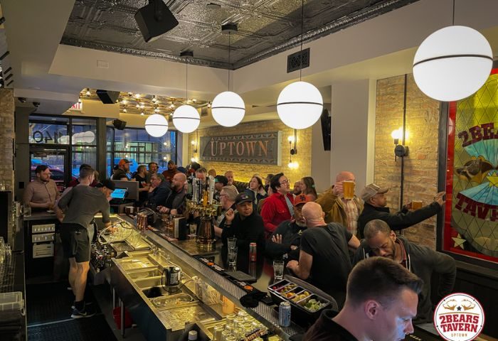 Inside 2Bears Tavern, an Uptown Chicago gay bar. Patrons at the bar, drinks, and a lively atmosphere. Gay travel advice.