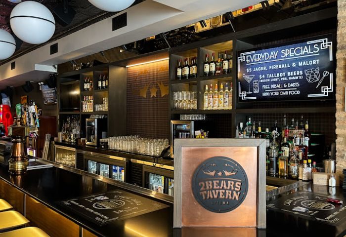 2Bears Tavern, an Uptown Chicago gay bar. Interior view of the bar, with bottles, glasses, and specials menu. Gay travel advice.