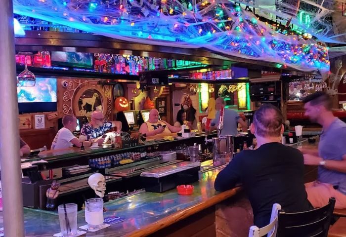 Mona's Cocktail Lounge interior. Gay bar with Halloween decor, men at the bar, and colorful lights. Gay travel in Key West. 3-10.jpg