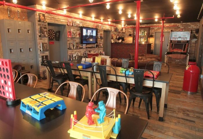 Hotel Gaythering's bar area. Interior of the gay hotel in Miami Beach, Florida. Tables with games for guests, bar, and lounge.