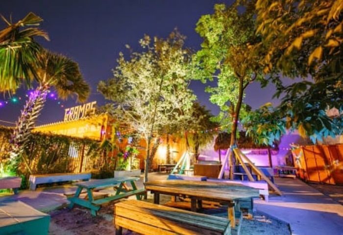 Gramps bar outdoor seating area at night. A popular gay travel destination with picnic tables, trees, and a festive atmosphere. 3-26.jpg