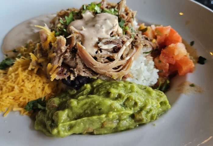 Georgie's ALIBI Monkey Bar food: rice bowl with pulled pork, guacamole, cheese, and pico de gallo. Gay travel food in Puerto Vallarta.