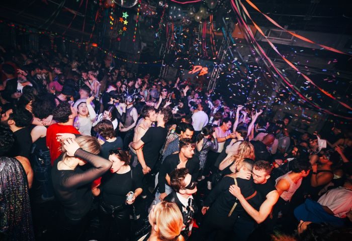 Gay nightlife in New York. A crowded dance floor at 3 Dollar Bill in New York, confetti falling, with gay men dancing and kissing.