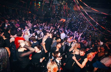 Gay nightlife in New York. A crowded dance floor at 3 Dollar Bill in New York, confetti falling, with gay men dancing and kissing.