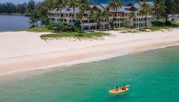 SAii Laguna Phuket resort view. Sandy beach meets turquoise sea. Kayak with two people. Palm trees. Ideal gay travel destination. 361483622.jpg