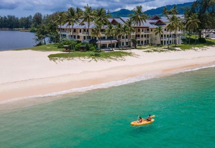 SAii Laguna Phuket resort view. Sandy beach meets turquoise sea. Kayak with two people. Palm trees. Ideal gay travel destination. 361483622.jpg