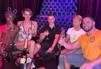 Five men toasting at a Boardwalk Bar. Champagne bottle in ice bucket. Gay travel nightlife. 4-11.jpg.