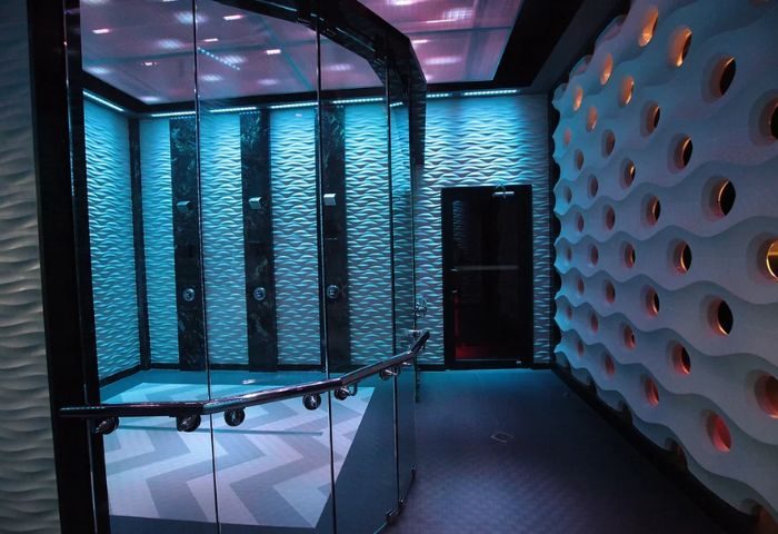 The Club Fort Lauderdale's interior features modern showers with blue lighting and textured walls. A sleek design for gay men's travel, 4-13.jpg.