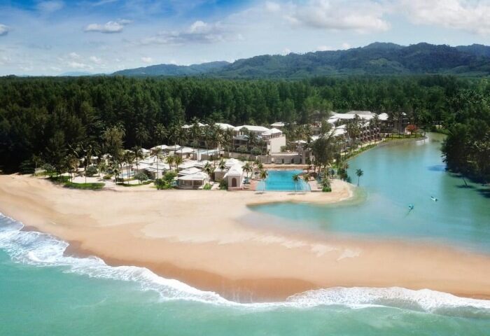 Devasom Khao Lak Beach Resort & Villas aerial view. Beachfront property with pool, villas, and lush greenery. Gay travel destination.