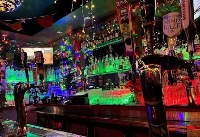 Interior of a gay bar in Castro, San Francisco. Beer taps, bottles, and festive lights decorate the bar. Gay travel advice.