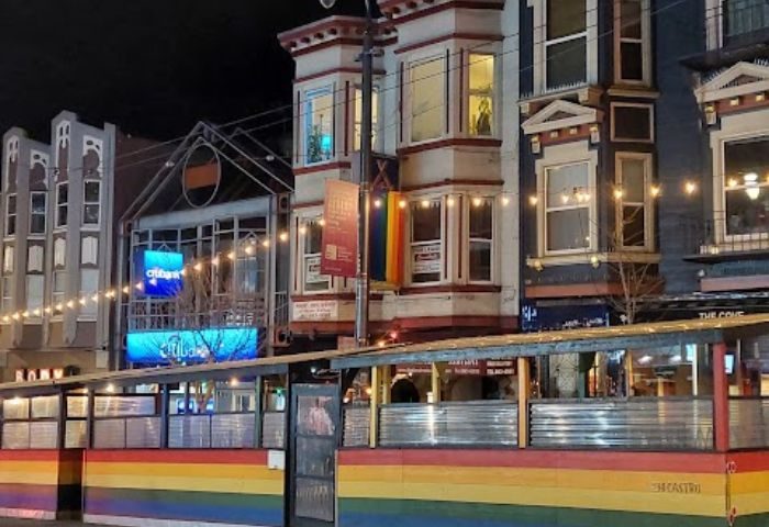 Castro gay bar in San Francisco with rainbow colors. A popular destination for gay men travel. Night scene with outdoor seating.
