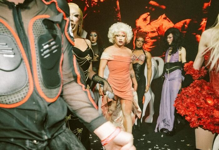 Medusa Realness drag show. Performers in costumes pose on stage. Gay travel nightlife scene.