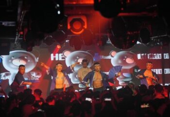 Gay travel destination: Go-go dancers entertain a crowd at a gay club. Nightlife scene with shirtless men. Party atmosphere.