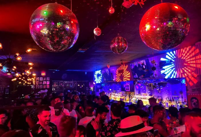 Crowded Nathan's Beach Club bar with disco balls, red and blue lights. Gay travel nightlife scene at a popular gay bar. 5-21.jpg