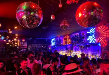 Crowded Nathan's Beach Club bar with disco balls, red and blue lights. Gay travel nightlife scene at a popular gay bar. 5-21.jpg