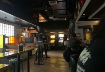 Gramps gay bar interior. Pinball machines, bar seating, and spooky decor create a unique atmosphere for gay men's travel experiences.