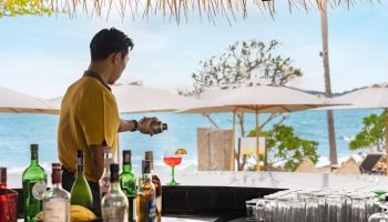 SAii Koh Samui Villas: Bartender pouring a cocktail at a beach bar. Tropical getaway for gay men's travel advice, 670806259.jpg.
