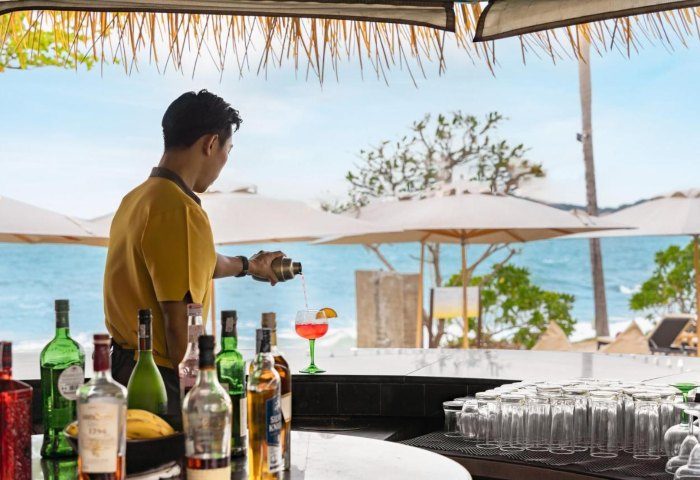 SAii Koh Samui Villas: Bartender pouring a cocktail at a beach bar. Tropical getaway for gay men's travel advice, 670806259.jpg.